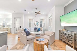 Un salon moderne avec un canapé, une table basse et un téléviseur.
