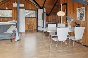 A modern interior with a dining area, kitchen, and seating space.