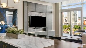A modern living room with a large TV, a marble countertop, and a view of the city through large windows. - Wyndham Vacation Resort Downtown ATL walking distance to MercedesBenz Stadium (Atlanta)
