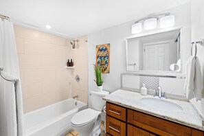 A modern bathroom with a bathtub, toilet, and sink.