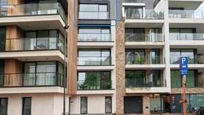 A modern multi-story building with balconies, large windows, and a parking sign indicating a maximum ticket limit. - Apartment in Blankenberge Near the Beach (Blankenberge)