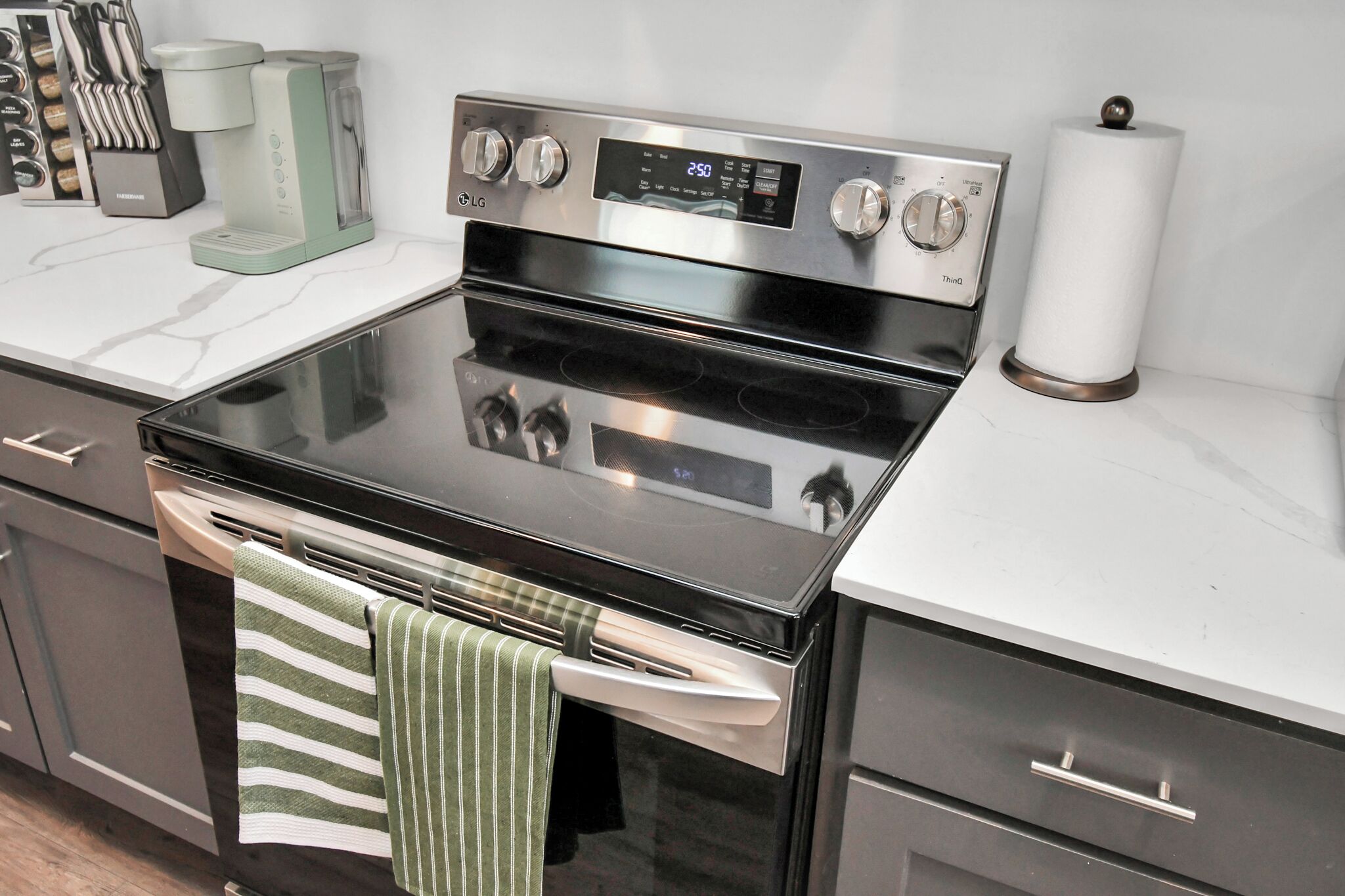 A kitchen with a stainless steel oven, a coffee maker, and a paper towel dispenser.
