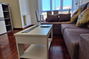 Un salon moderne avec un canapé, une table basse blanche et un radiateur.