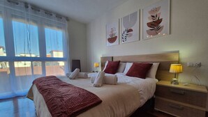 Habitación de hotel con cama, mesitas de noche, lámpara y cuadros en la pared.