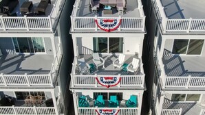 Un immeuble à plusieurs étages doté de balcons, dont certains sont aménagés avec du mobilier d’extérieur.