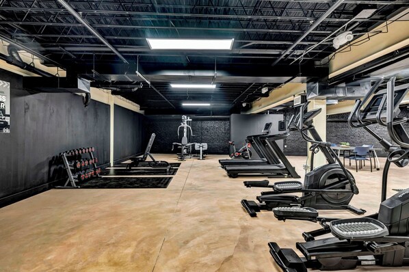 A gym with treadmills, elliptical machines, and free weights.