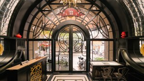 Un área de recepción con puerta de vidrio, mostrador de recepción y vista a la calle.