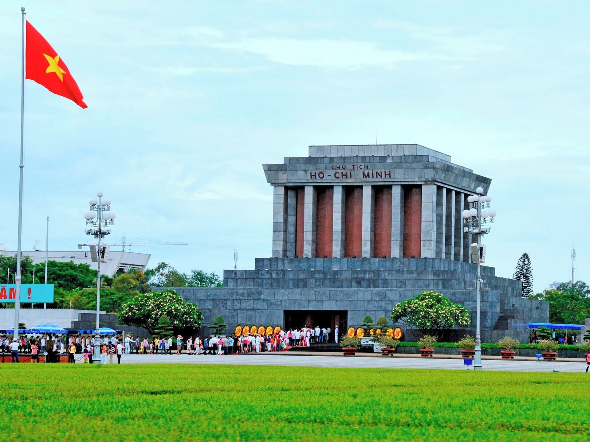 A large, imposing building with a prominent entrance and a flagpole with a flag.