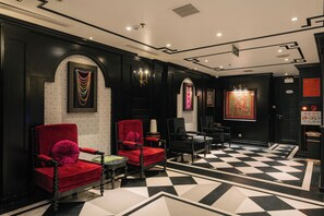 A lobby with a checkered floor, red and black armchairs, a chandelier, and a framed artwork on the wall. - Bay Luxury Beijing Hotel (Hanoi)
