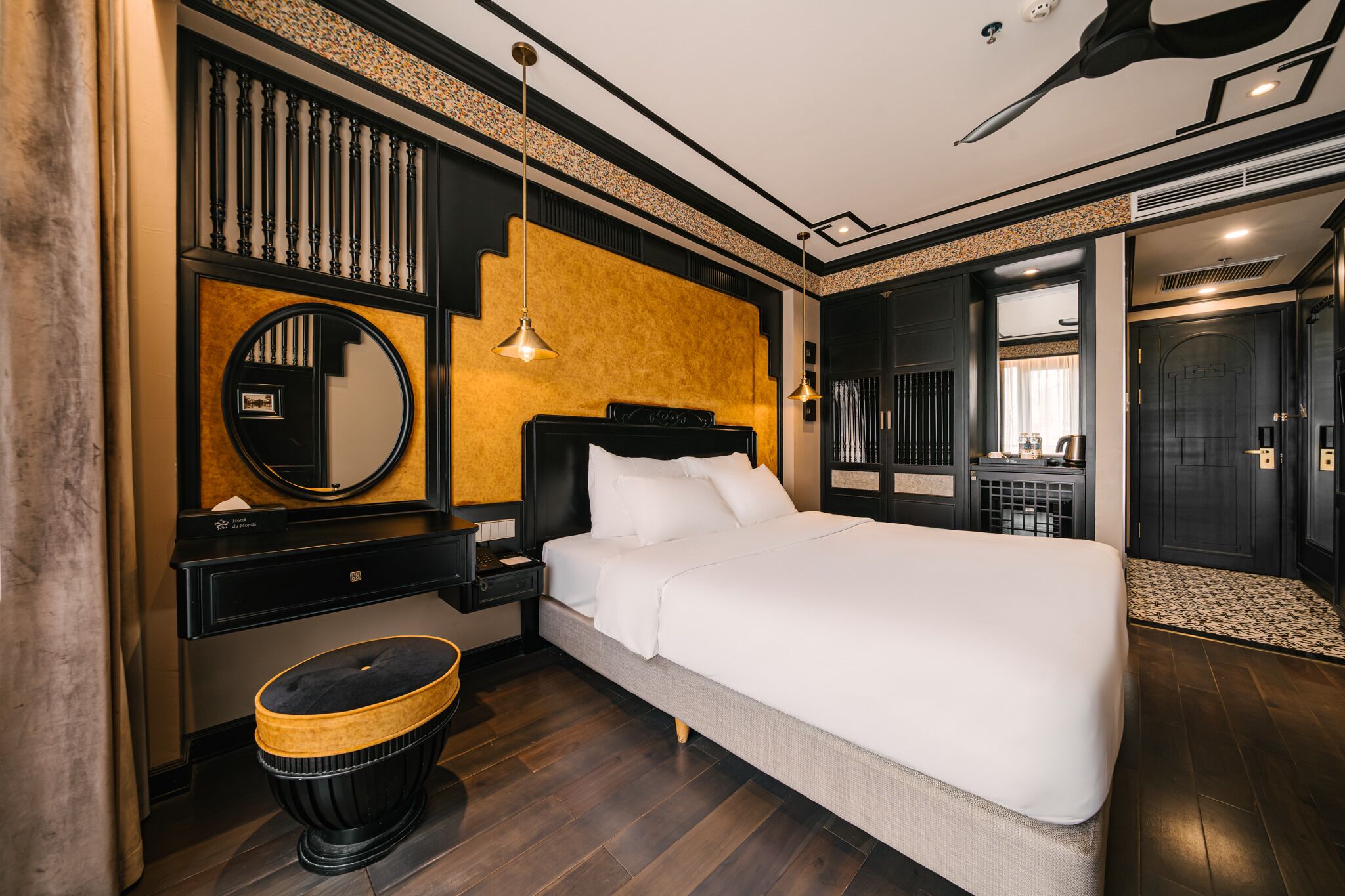 Ein modernes Hotelzimmer mit einem großen Bett, einem Nachttisch, einem Spiegel und einem Kleiderschrank.