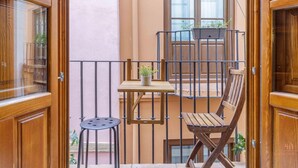 A balcony with a wooden table, two chairs, and a potted plant. - Rustic Chic Living4Malaga (Málaga)
