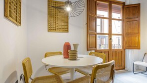 A dining area with a round table, six wicker chairs, and two vases. - Rustic Chic Living4Malaga (Málaga)