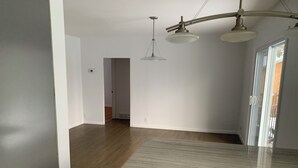 A spacious room with a large kitchen area, a wooden floor, and a modern pendant light fixture. - Manotick waterfront property. Walking distance to pubs restaurants. groceries.
 (Ottawa)