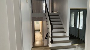 A staircase with a black handrail leading to a landing. - Manotick waterfront property. Walking distance to pubs restaurants. groceries.
 (Ottawa)
