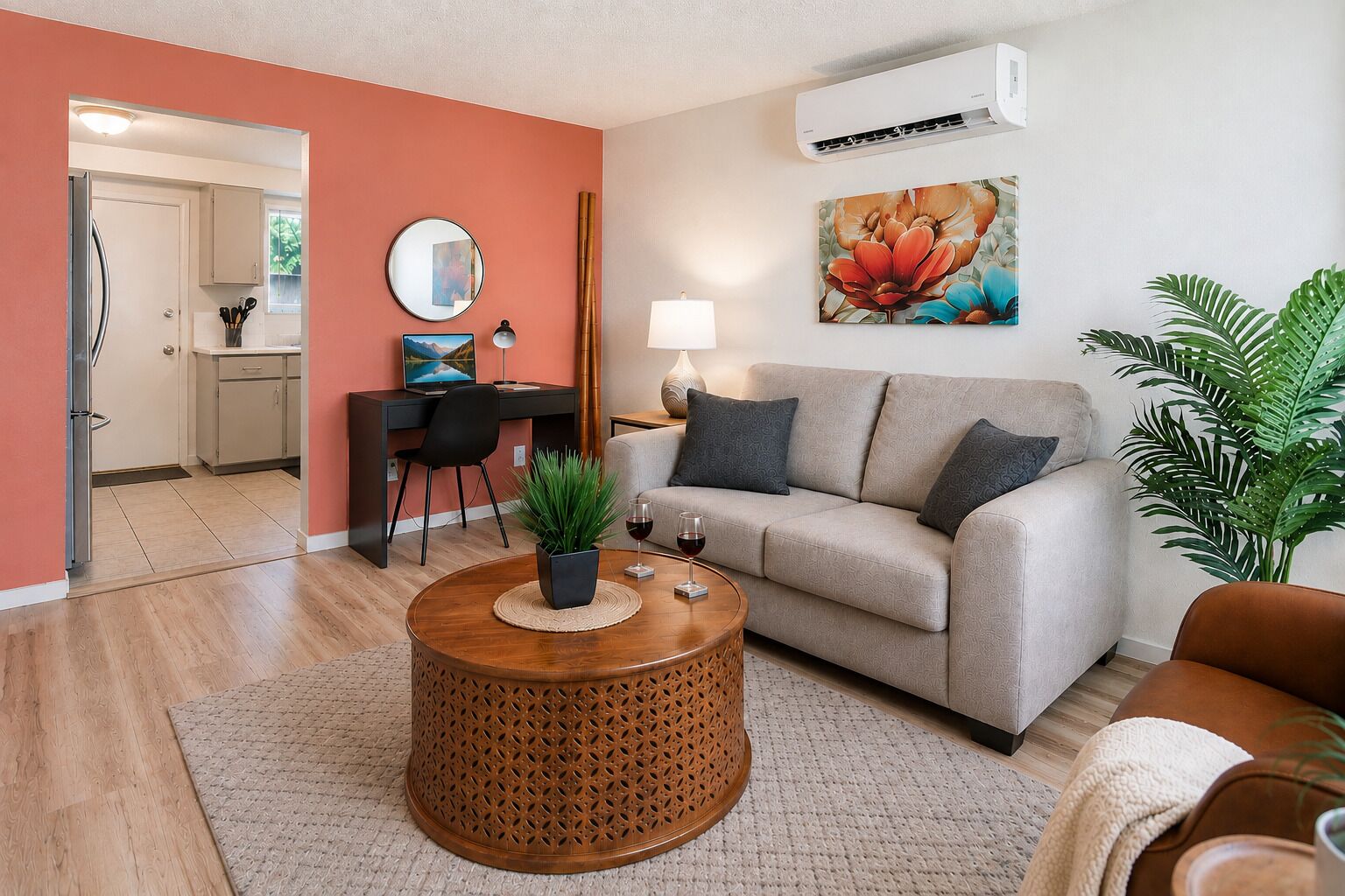 A modern living room with a sofa, coffee table, and a dining area with a desk and chair.