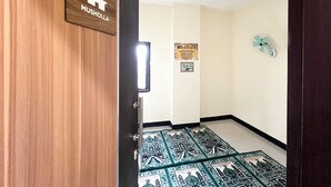 A hallway with a wooden door labeled 'MUSHOLLA'. - Wisma Saranani (Kendari)