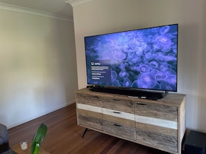 Un téléviseur à écran plat posé sur un meuble en bois doté de tiroirs, affichant un écran de configuration réseau.