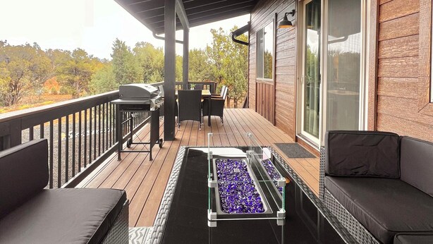 Una terraza techada al aire libre con una parrilla, una zona de estar y un brasero.