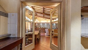 Un interior rústic amb sostre de fusta, paret de pedra i terra de rajola.