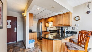 A kitchen with wooden cabinets, a central island, and a built-in refrigerator. - Breck Ski-In/Ski-Out Condo with Resort Amenities (Breckenridge)