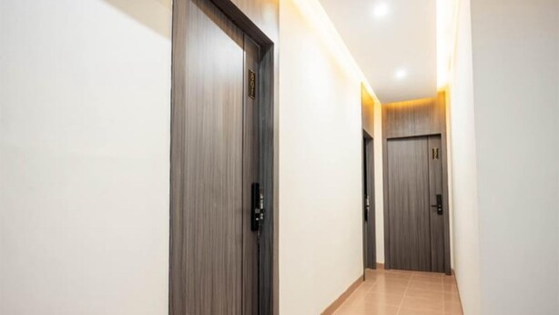 Un pasillo con puertas de madera y piso de baldosas.