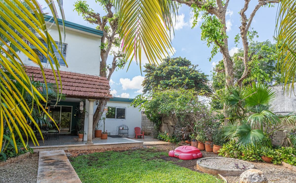A well-maintained garden with a variety of plants and a small seating area.