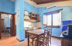 Una cocina con mesa y sillas de madera, estufa y armarios.