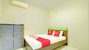 Un dormitorio con cama, armario y aire acondicionado.