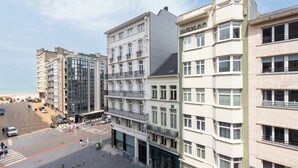 A multi-story hotel with a modern facade, large windows, and a ground-level entrance. - Apartment in Ostend Near Shopping Street (Ostend)