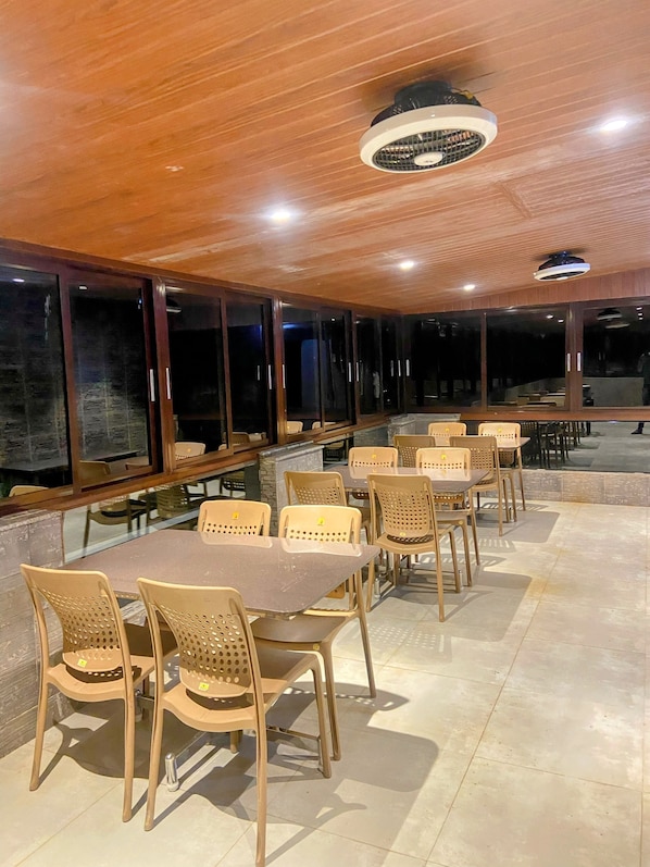 Un comedor amplio e interior con techos altos y ventanas grandes, que ofrece abundante luz natural.