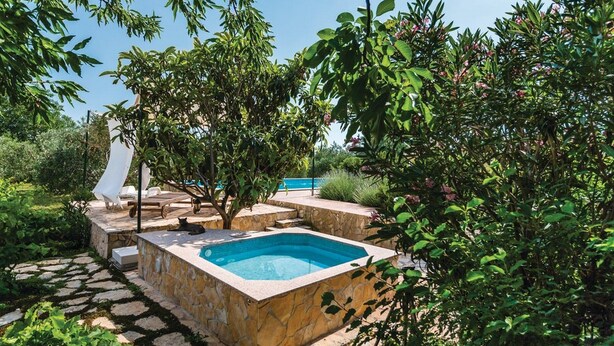 A private outdoor pool area with a stone deck, lounge chairs, and a small hot tub. - Picturesque Escape Holiday Home With Pool and Sauna (Kastela)