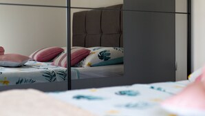 Un dormitorio con cama, almohadas y armario.