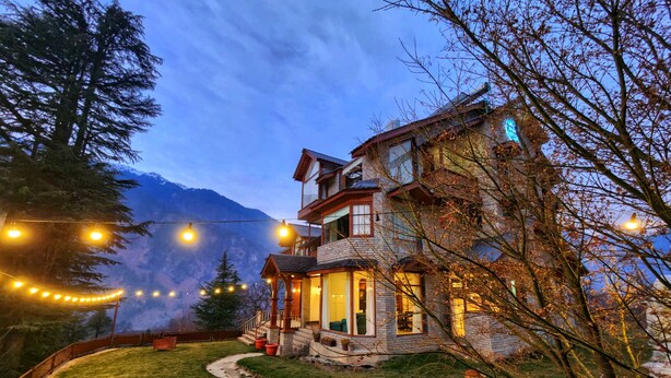 A two-story house with a stone facade, a balcony, and a stone pathway leading to the entrance. - Hygge Home Manali (Manali)