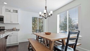 A kitchen with white cabinets, a wooden dining table, a bench, and a chandelier. - 10 Minutes to the Unitas! Full-Home Francis Rental (Kamas)