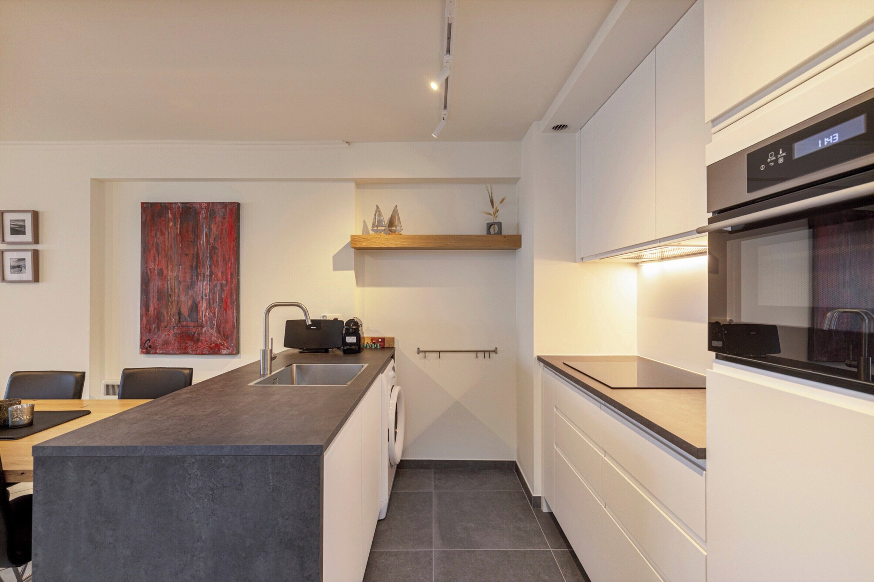 A modern kitchen with a central island, built-in appliances, and a minimalist design.