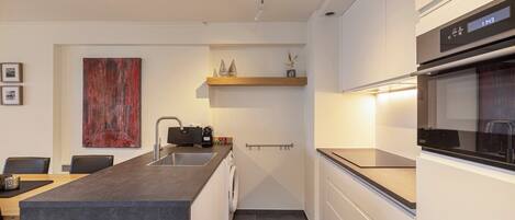 A modern kitchen with a central island, built-in appliances, and a minimalist design.