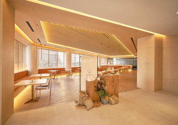 A spacious, modern interior with wooden paneling, large windows, and neatly arranged tables and chairs. - UH Continental CenterPoint (Busan)