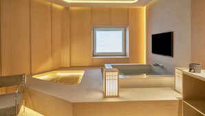 A modern bathroom with a freestanding bathtub, a built-in shower, and a vanity with a mirror. - UH Continental CenterPoint (Busan)