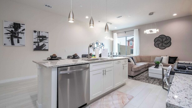 A modern kitchen with a central island, stainless steel appliances, pendant lighting, and minimalist decor. - Luxury 3BR home with Mario Bros Room Near Disney (Kissimmee)