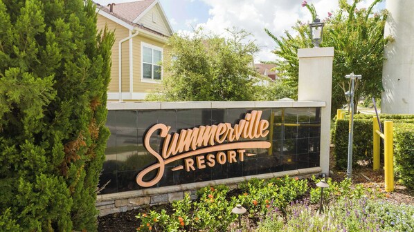 Une enseigne pour le Summerville Resort, avec un fond noir et des lettres dorées.