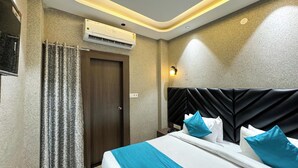 A hotel room with a bed, a nightstand, an air conditioning unit, and a wall-mounted light fixture. - Wanna stay haridwar  (Haridwar)