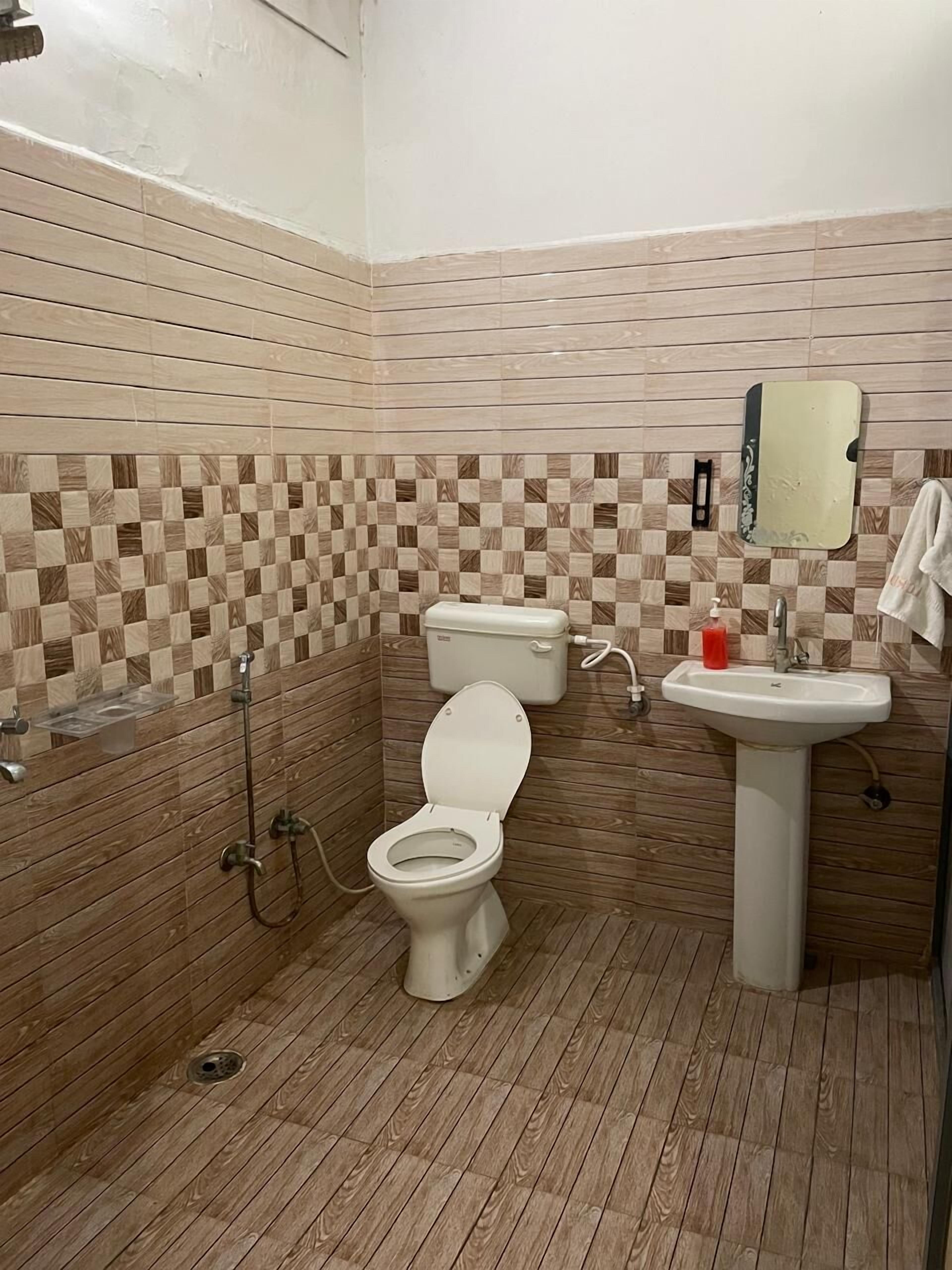 A bathroom with a toilet, sink, and shower.