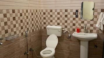 A bathroom with a toilet, sink, and shower.