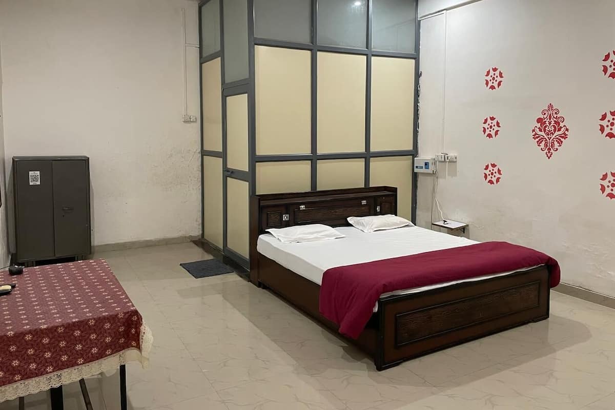 Une chambre à coucher avec un lit, une table et une armoire.