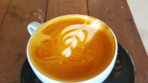 A cup of coffee with latte art on a saucer. - The Moon House for Entrepreneurs (Dalung)
