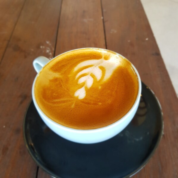 A cup of coffee with latte art on a saucer. - The Moon House for Entrepreneurs (Dalung)