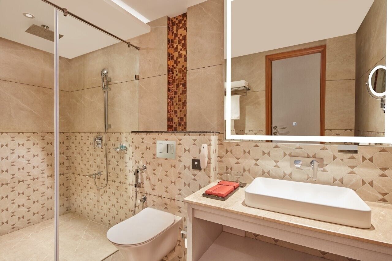 A modern bathroom with a shower, toilet, and sink.