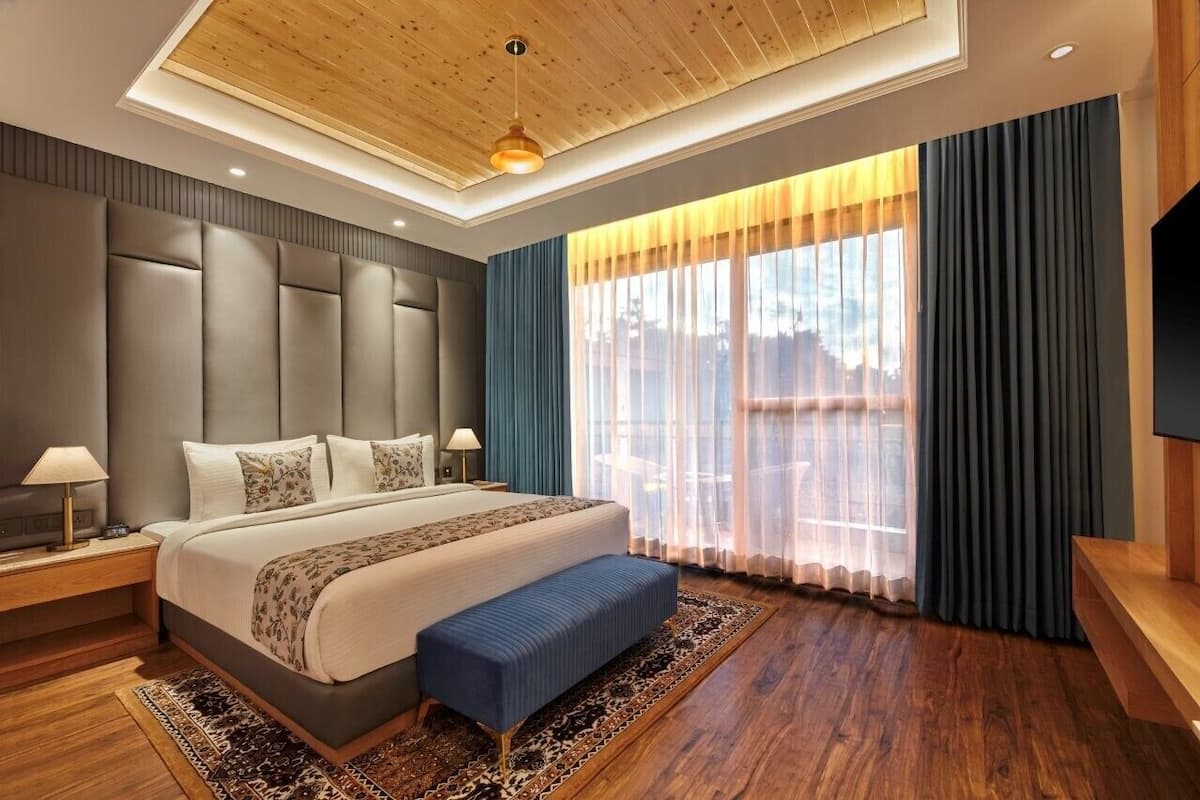 Een moderne hotelkamer met een groot bed, een houten plafond en een ruim raam met gordijnen.