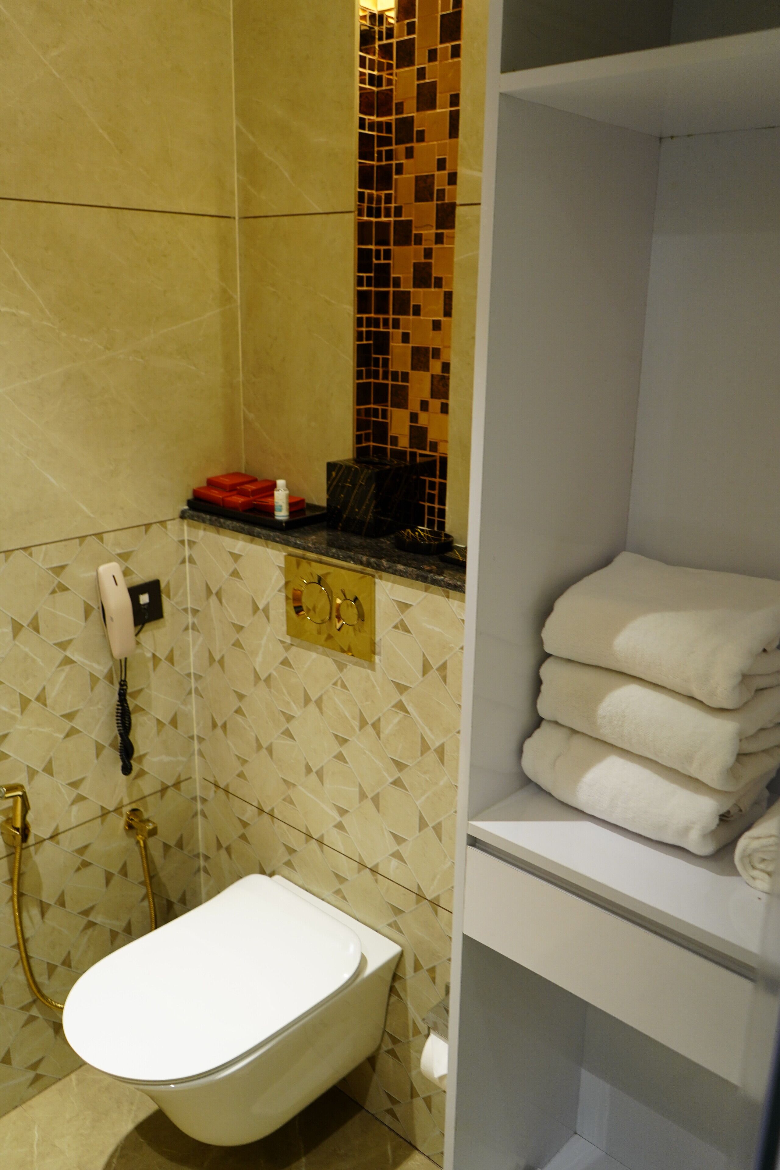 A bathroom with a toilet, a shower, and a towel rack.