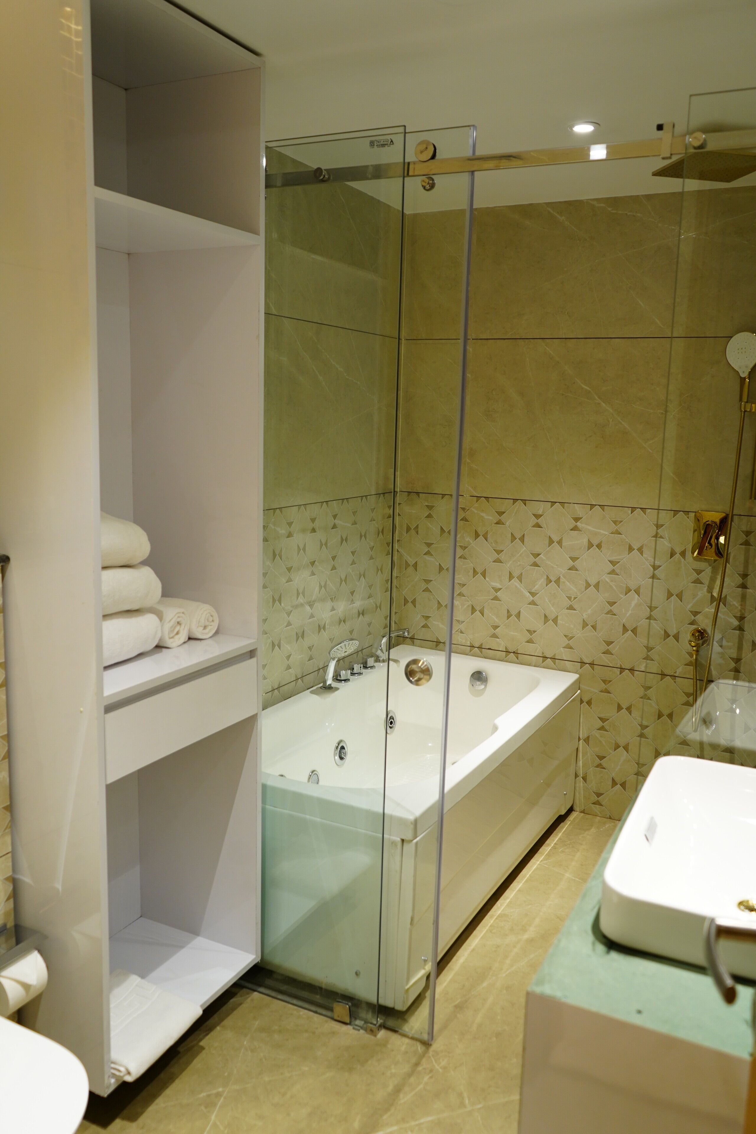 A modern bathroom with a glass-enclosed shower, a bathtub, and a sink.